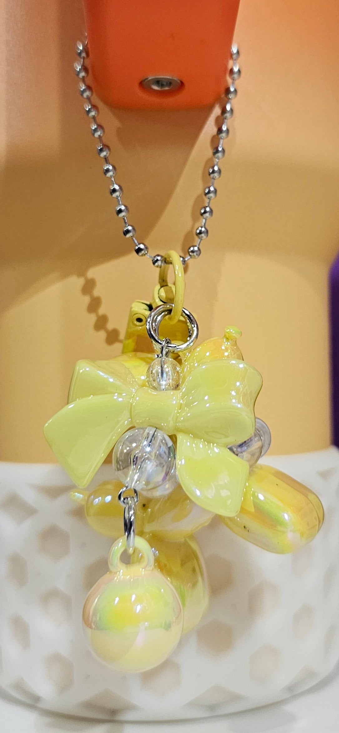 Iridescent Pearlescent Yellow Balloon Dog with Ribbon Bow and bead charm pendant. Use to accessorize tumbler straw, tumbler handle, purse, backpack, keychain, or cellphone.