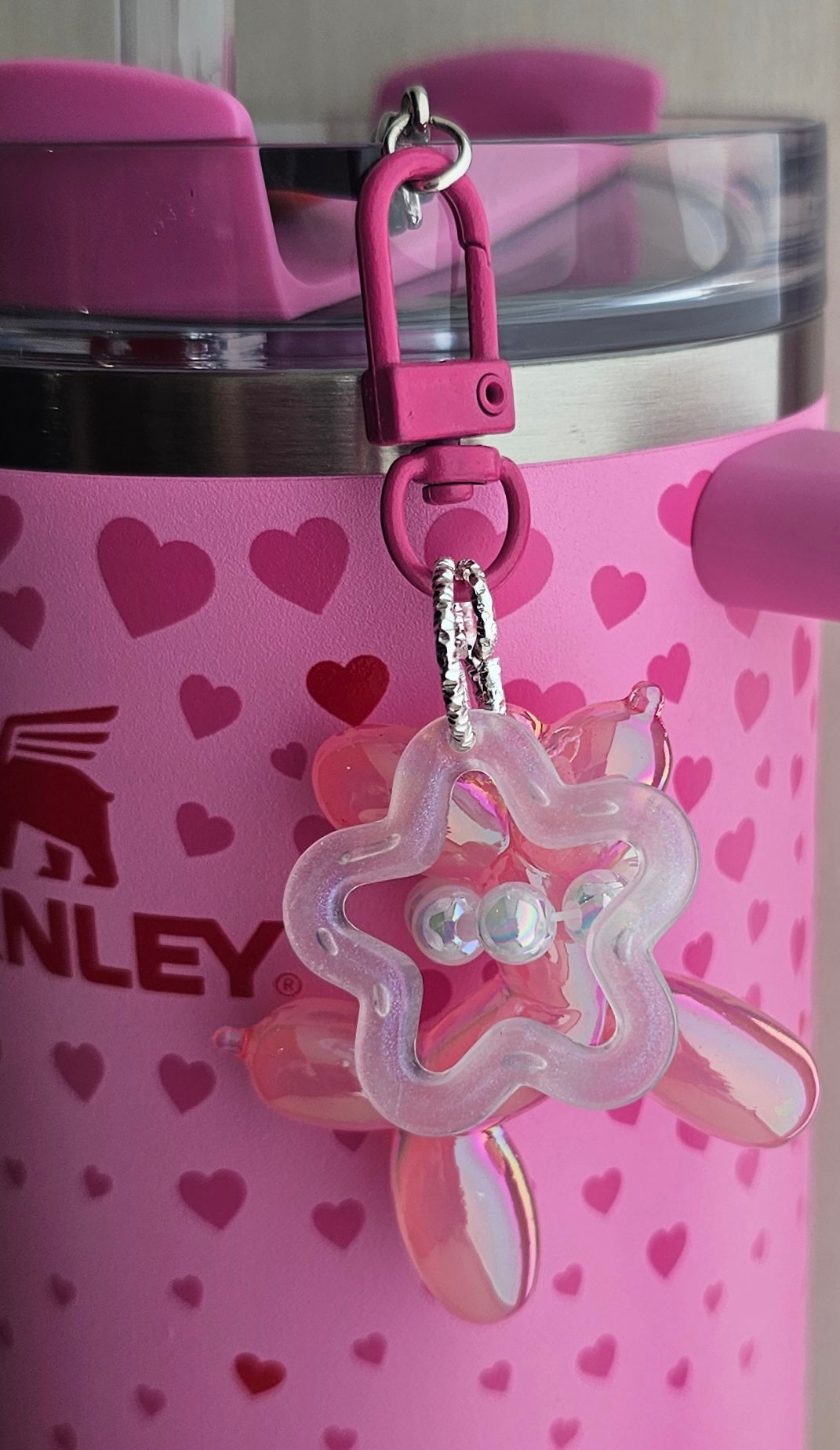 Iridescent Pearlescent pink balloon dog charm pendant used as a Stanley straw charm accessory.