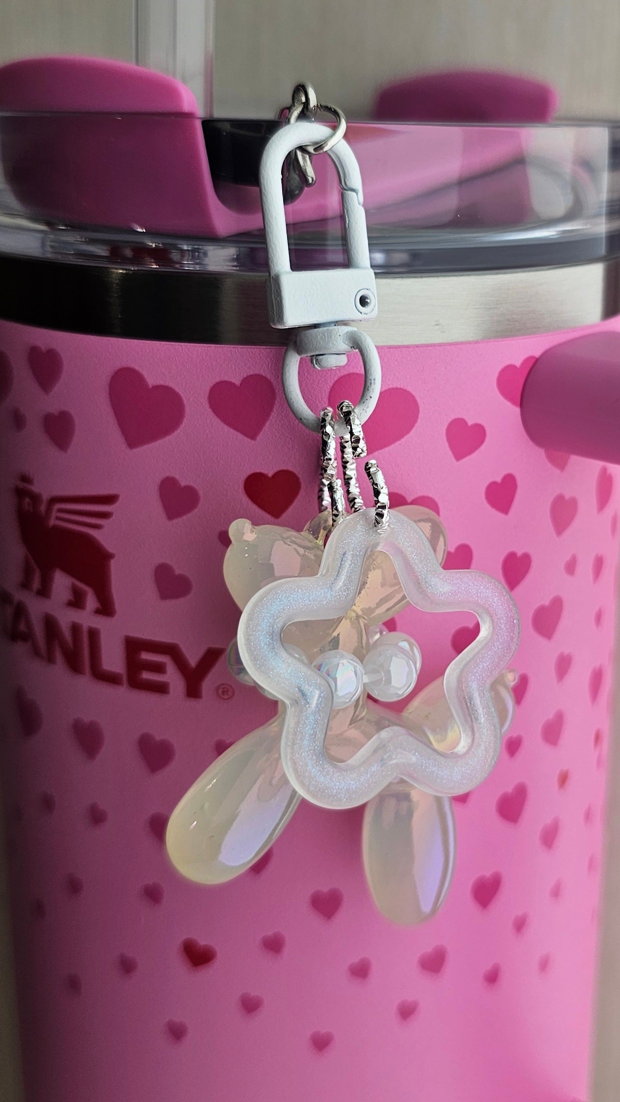 Iridescent Pearlescent white balloon dog charm pendant used as a Stanley straw charm accessory.