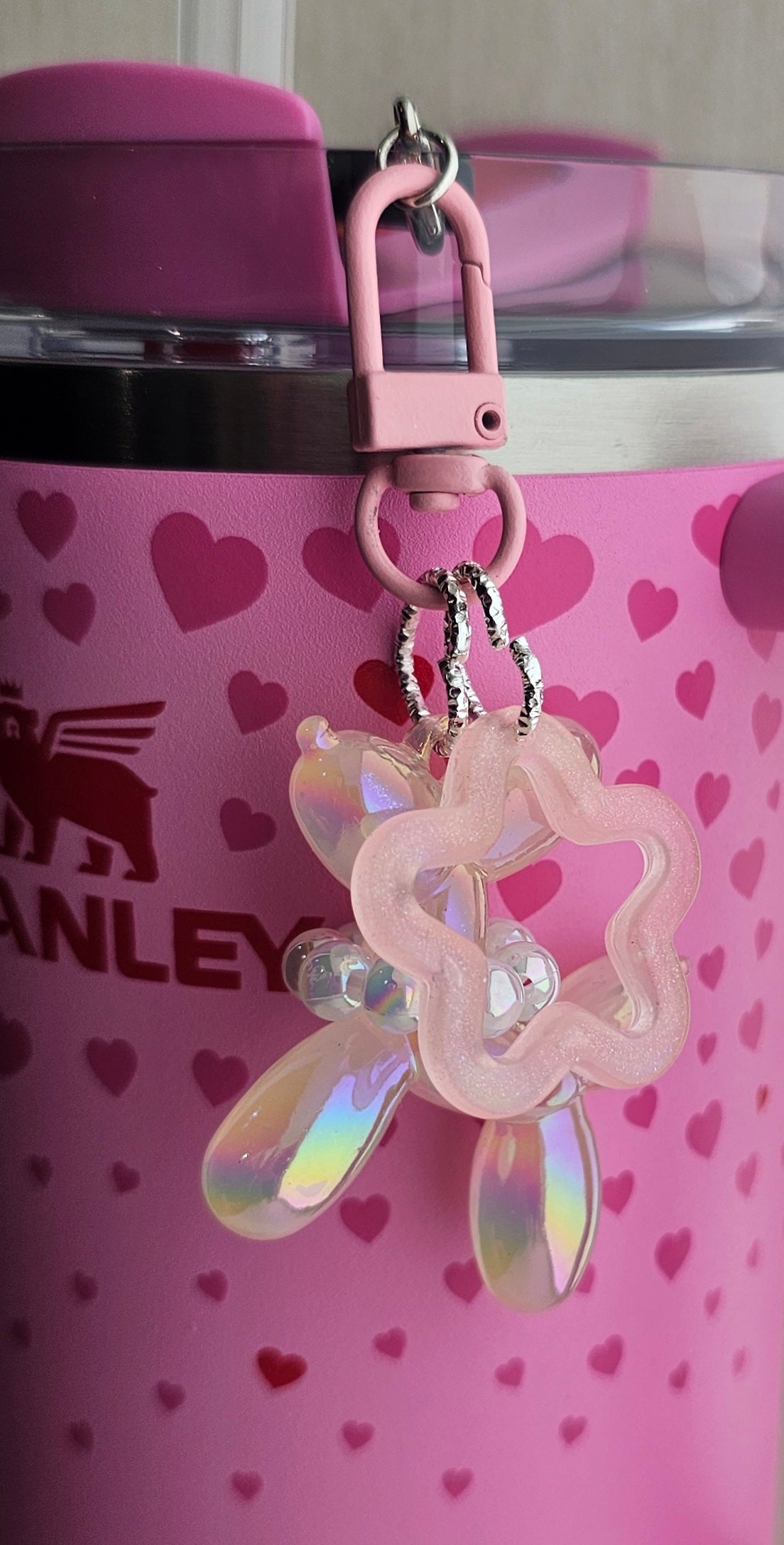 Iridescent Pearlescent Blush Pink balloon dog charm pendant used as a Stanley straw charm accessory.