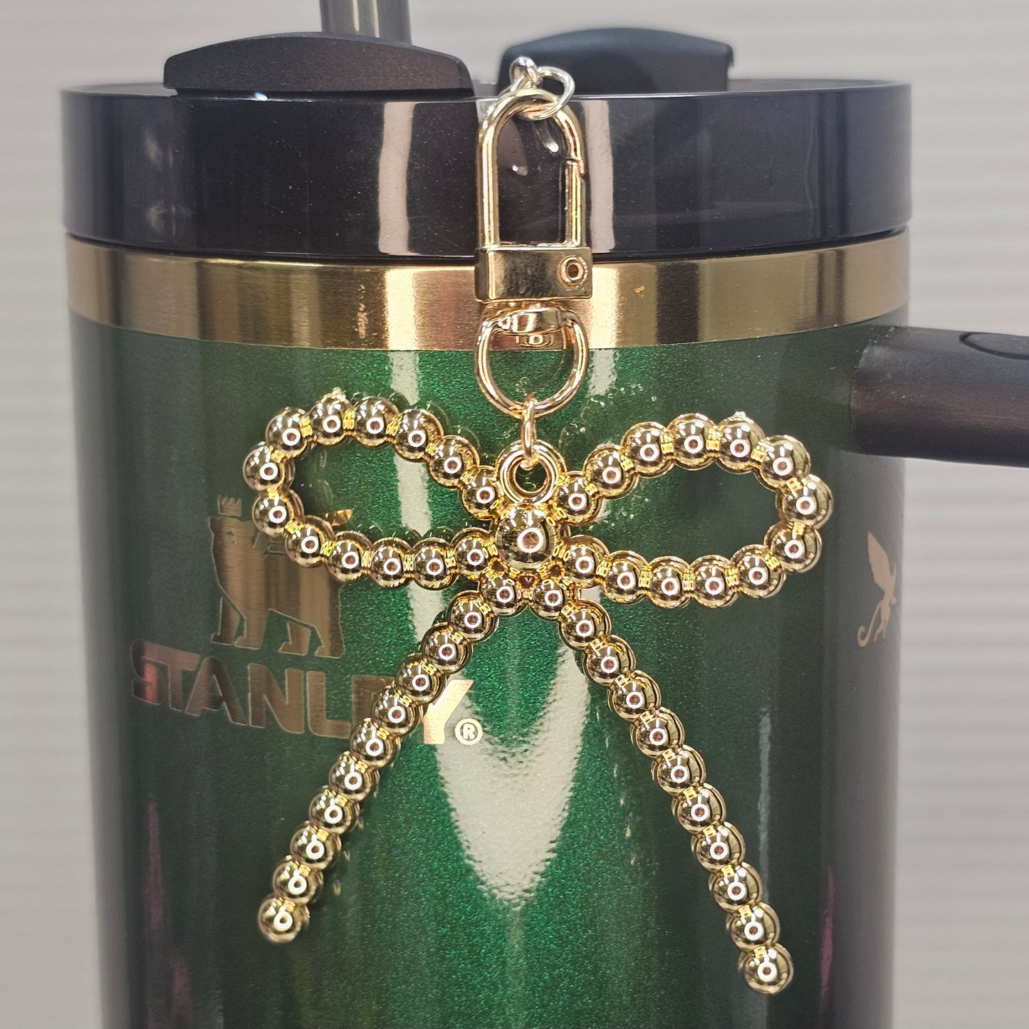 Gold beaded bow tumbler charm.