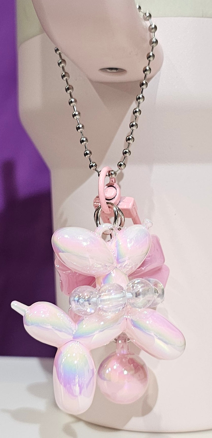 Iridescent Pearlescent Pink Balloon Dog with Ribbon Bow and bead charm pendant. Use to accessorize tumbler straw, tumbler handle, purse, backpack, keychain, or cellphone. 