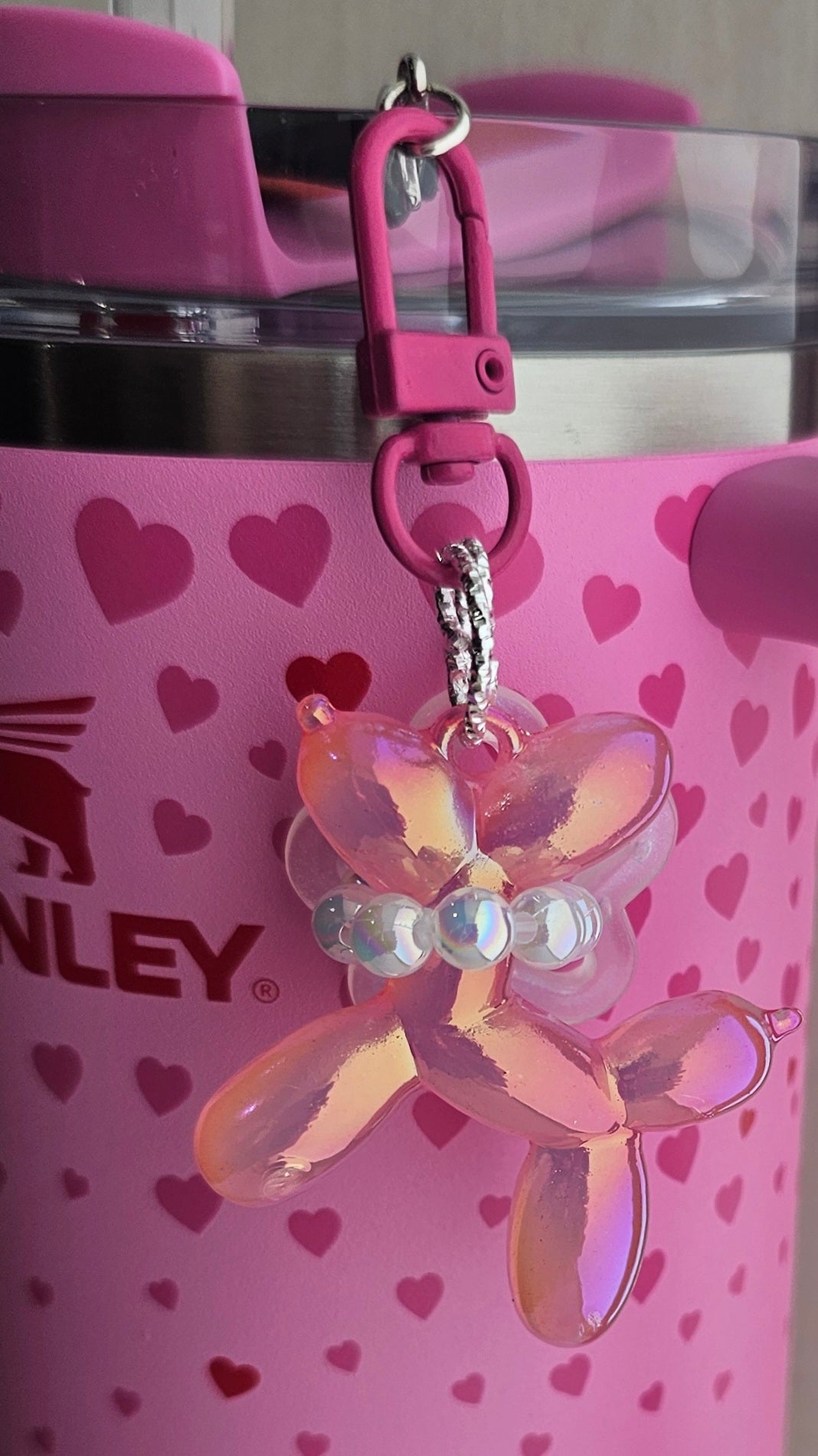 Iridescent Pearlescent pink balloon dog charm pendant used as a Stanley straw charm accessory. 