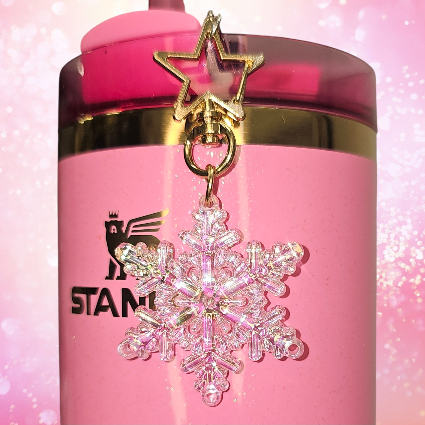 Pearlescent pink Snowflake tumbler straw charm with gold star clasp. Taken with flash. 