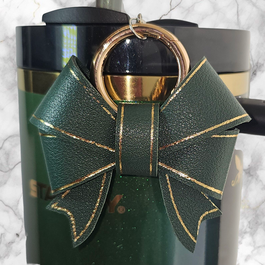 A luxury hunter green faux leather bow trimmed in gold charm pendant that can be used as a charm for your tumbler, tumbler straw, purse, bag, keychain, backpack, or cellphone. 