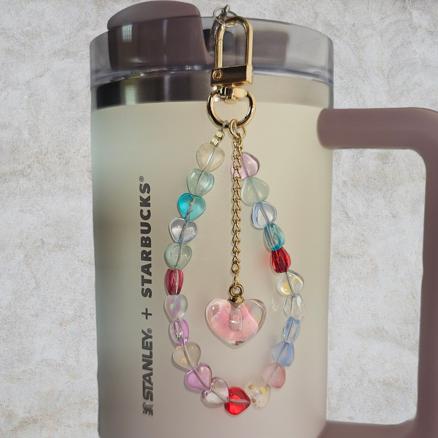 Deluxe Crystal Heart Beaded Tumbler Charm. 
Iridescent Pearlescent Pink Crystal Heart Beaded Tumbler Charm. 

Beads are multicolored. There are 3 styles so please reference the image linked to the style number when choosing. 