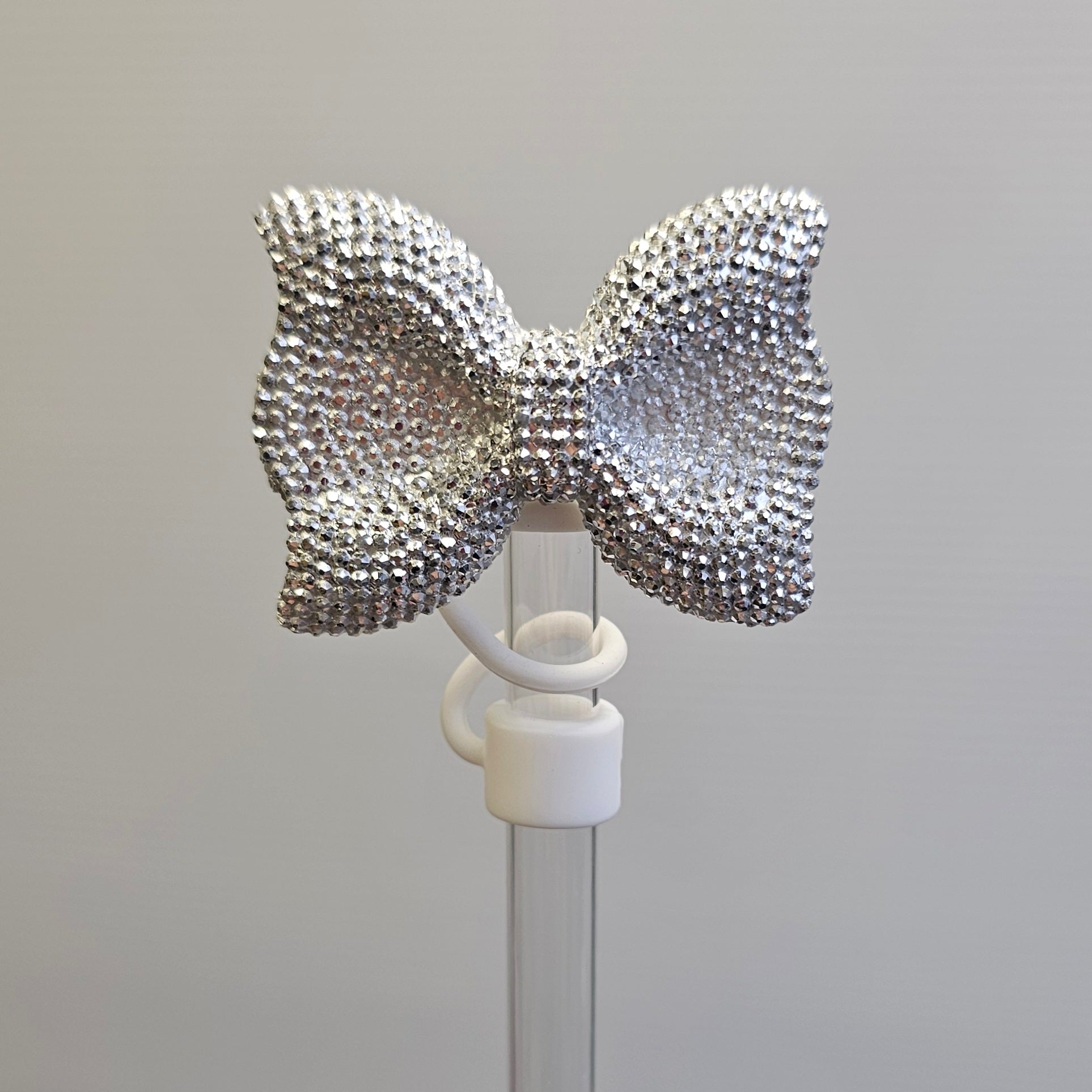 Silver Bow Tie Silicone Straw Topper with White Silicone Straw Topper base. 