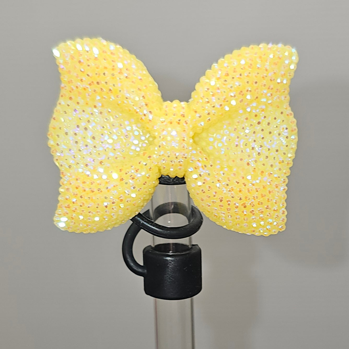 Glitter Yellow bow tie with Black Silicone base - Straw Topper  - Straw Cover - Fits 10mm and Stanley Straws.
Taken with camera flash. 