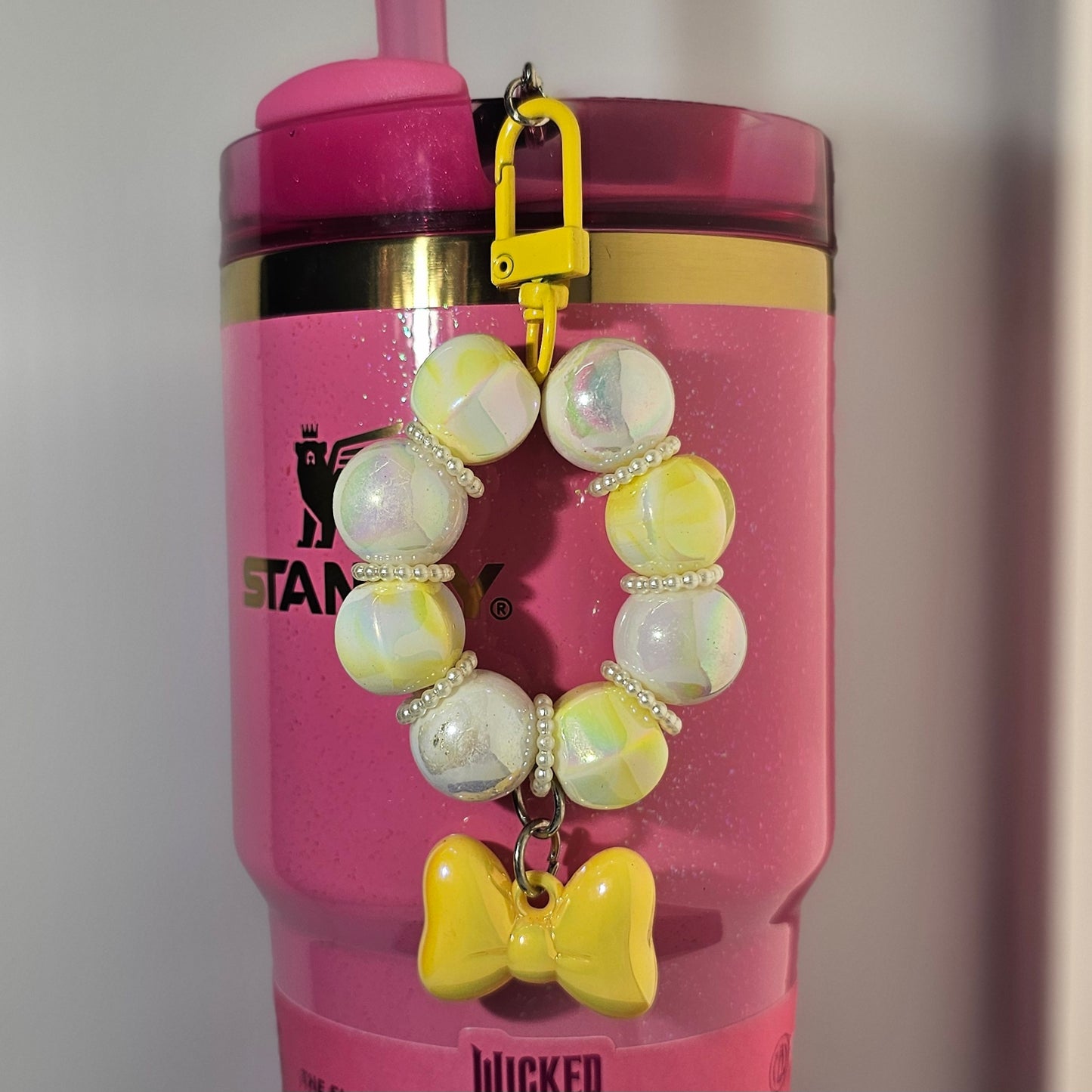 Yellow and white beaded bow tumbler straw charm. 