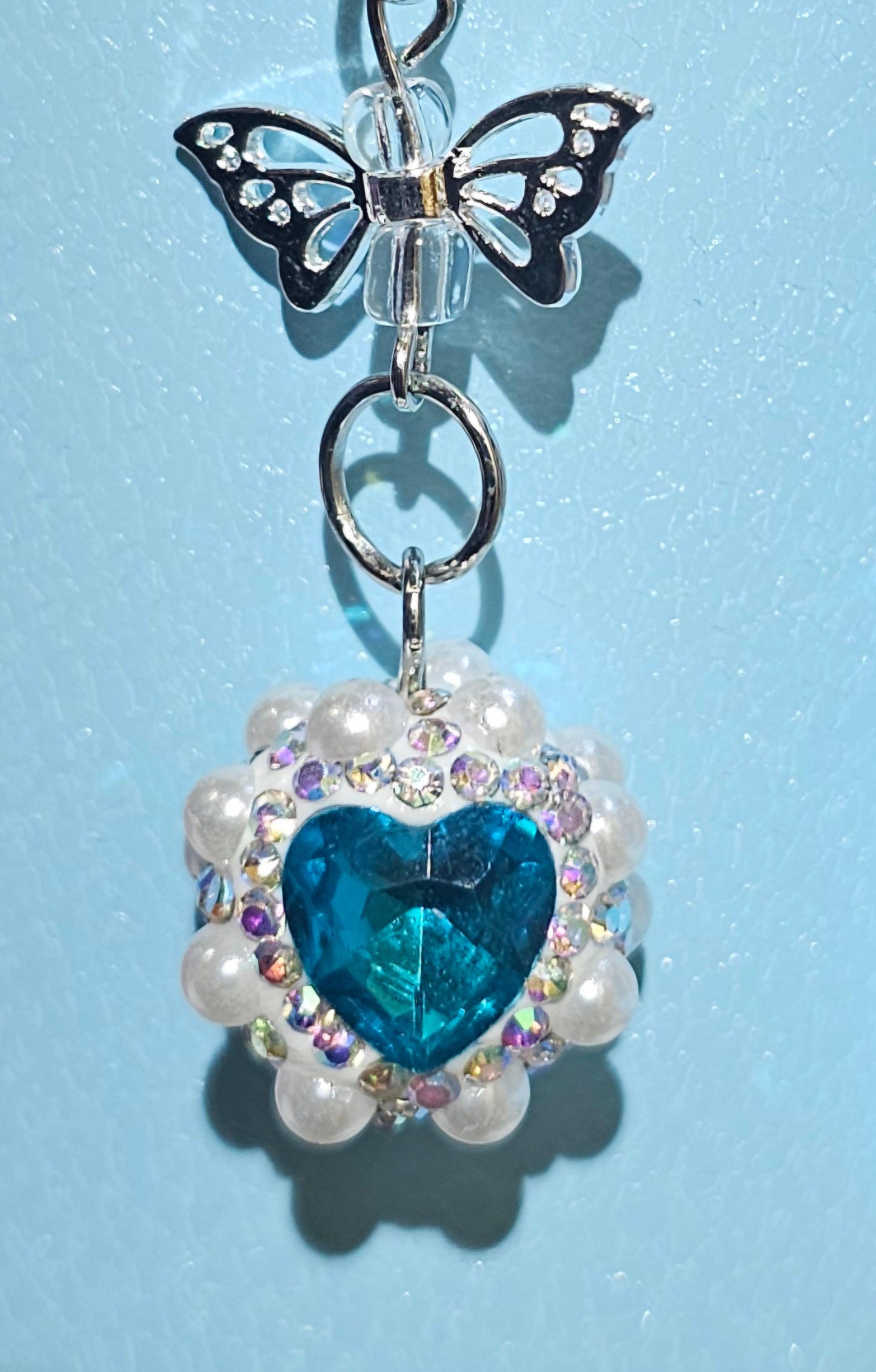 Iridescent Pearlescent Blue Heart Jewel trimmed with White Rhinestone Glitter and Silver Butterfly Charm Pendant - Southern Creative Glamour