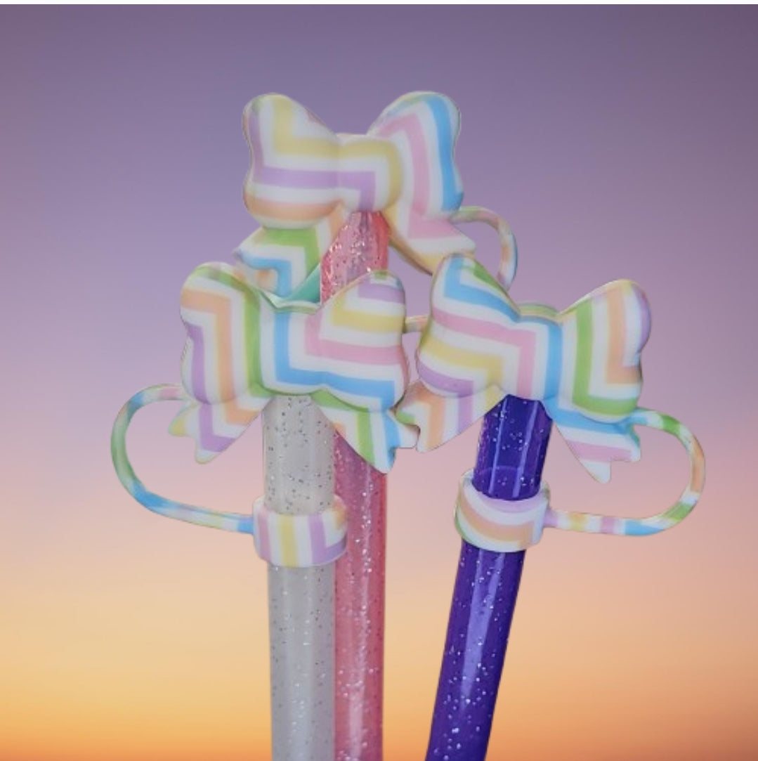 Coquette Ribbon Bow Silicone Straw Topper  - Easter Egg. Stripe colors are pink, purple, blue, green, orange, and yellow with a White background. 