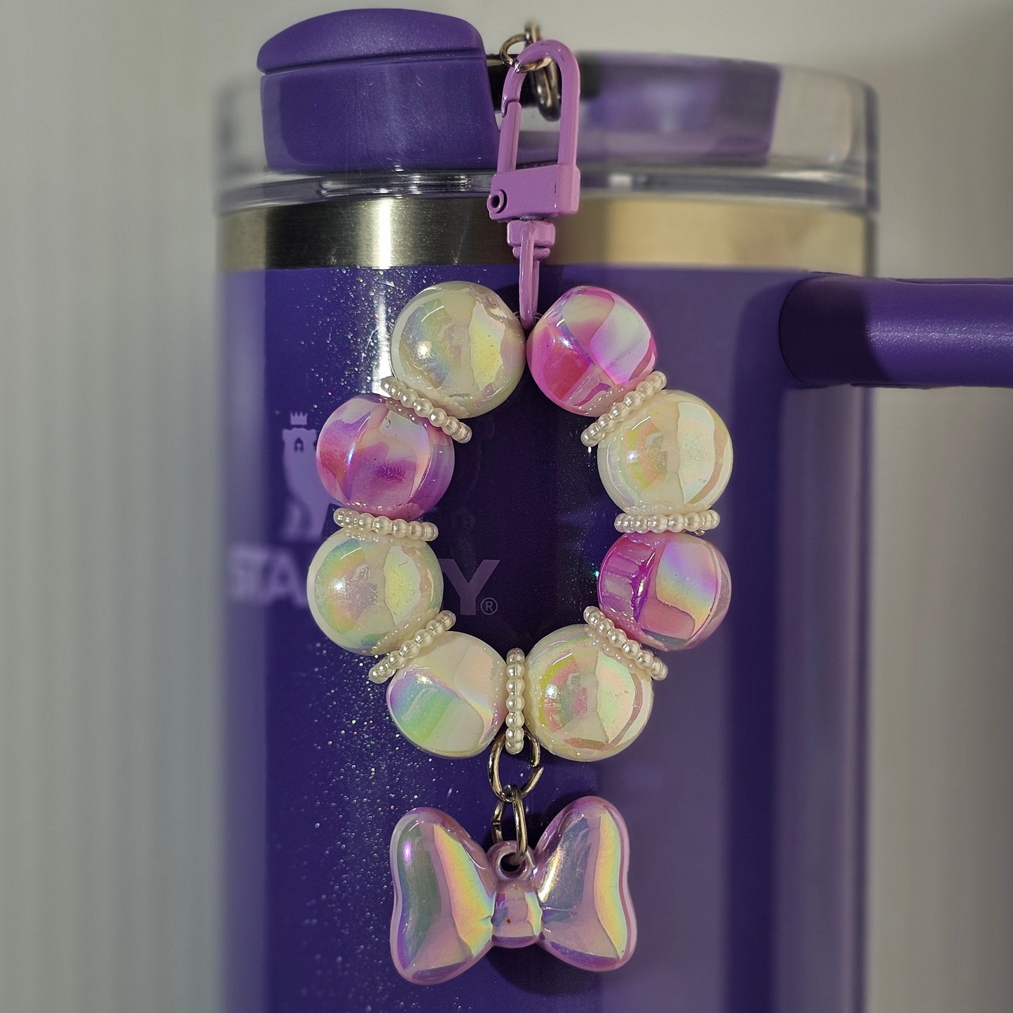 Purple and white beaded bow tumbler straw charm. 