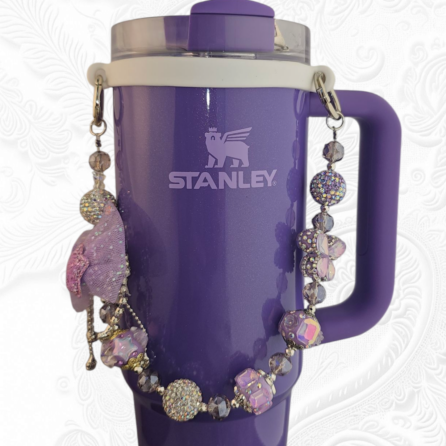 Deluxe Princess Beaded Tumbler Charm Necklace - Lavender Purple 
Iridescent Pearlescent Lavendar Purple Crystal Beaded Tumbler Charm Necklace. 

The center piece of this beautiful charm is the Jumbo Purple bow tie that is double-sided. One side has a purple sequin star while the other side has a crystal butterfly and diamonds. (diamonds are not real)