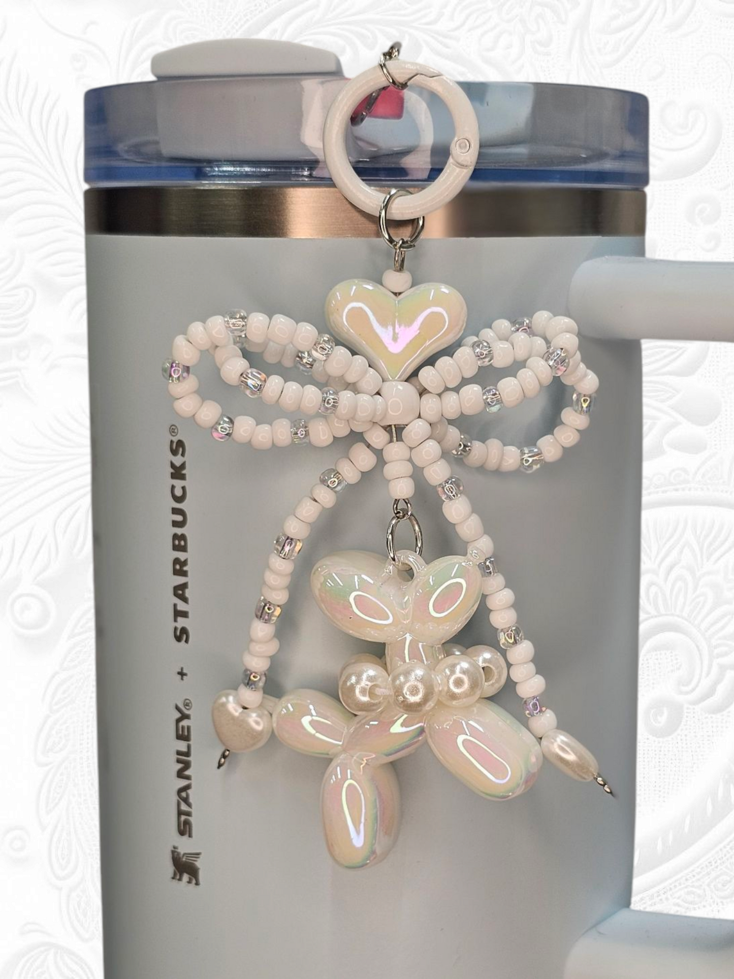 White beaded ribbon bow, white heart, and pearlescent white balloon dog charm pendant. 