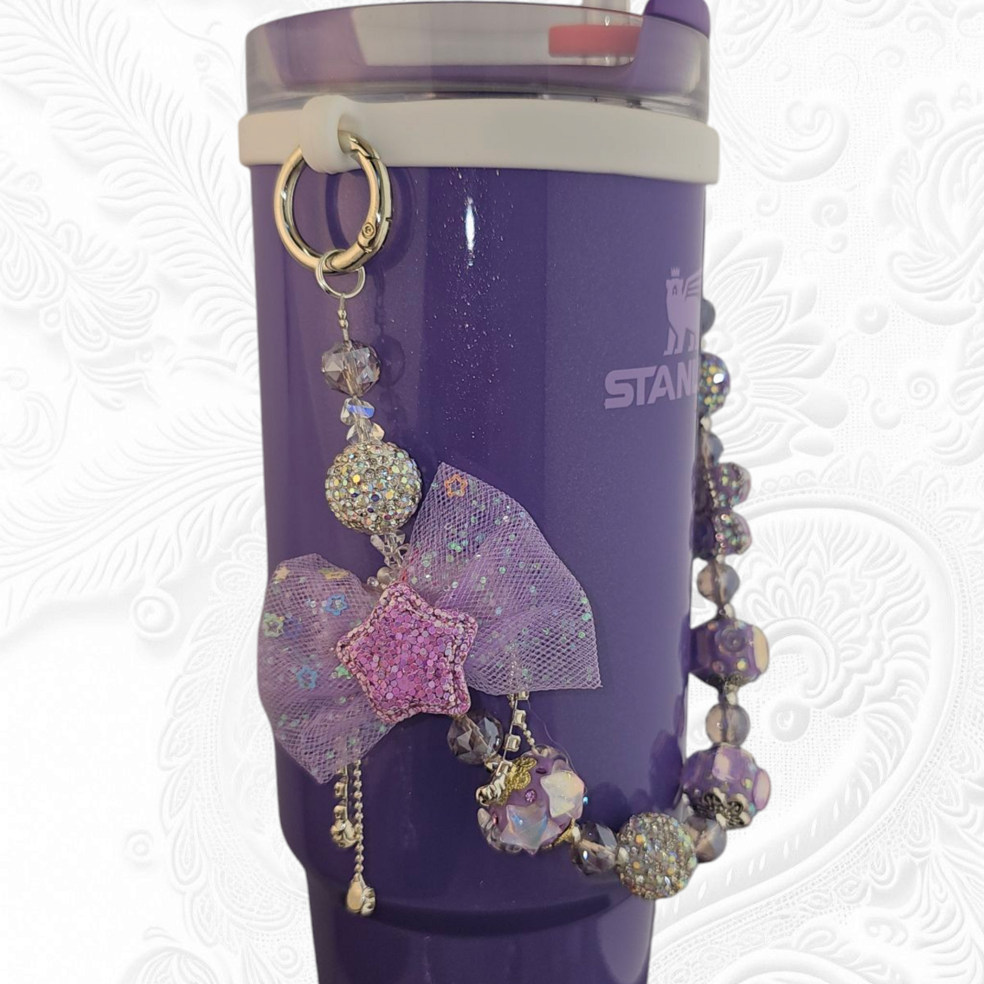 Deluxe Princess Beaded Tumbler Charm Necklace - Lavender Purple 
Iridescent Pearlescent Lavendar Purple Crystal Beaded Tumbler Charm Necklace. 

The center piece of this beautiful charm is the Jumbo Purple bow tie that is double-sided. One side has a purple sequin star while the other side has a crystal butterfly and diamonds. (diamonds are not real)